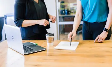 deux professionnels collaborent autour d'un bureau avec laptop et café