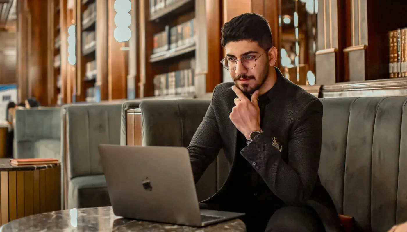 manager réfléchissant à son ordinateur dans une bibliothèque, symbolisant le leadership éthique