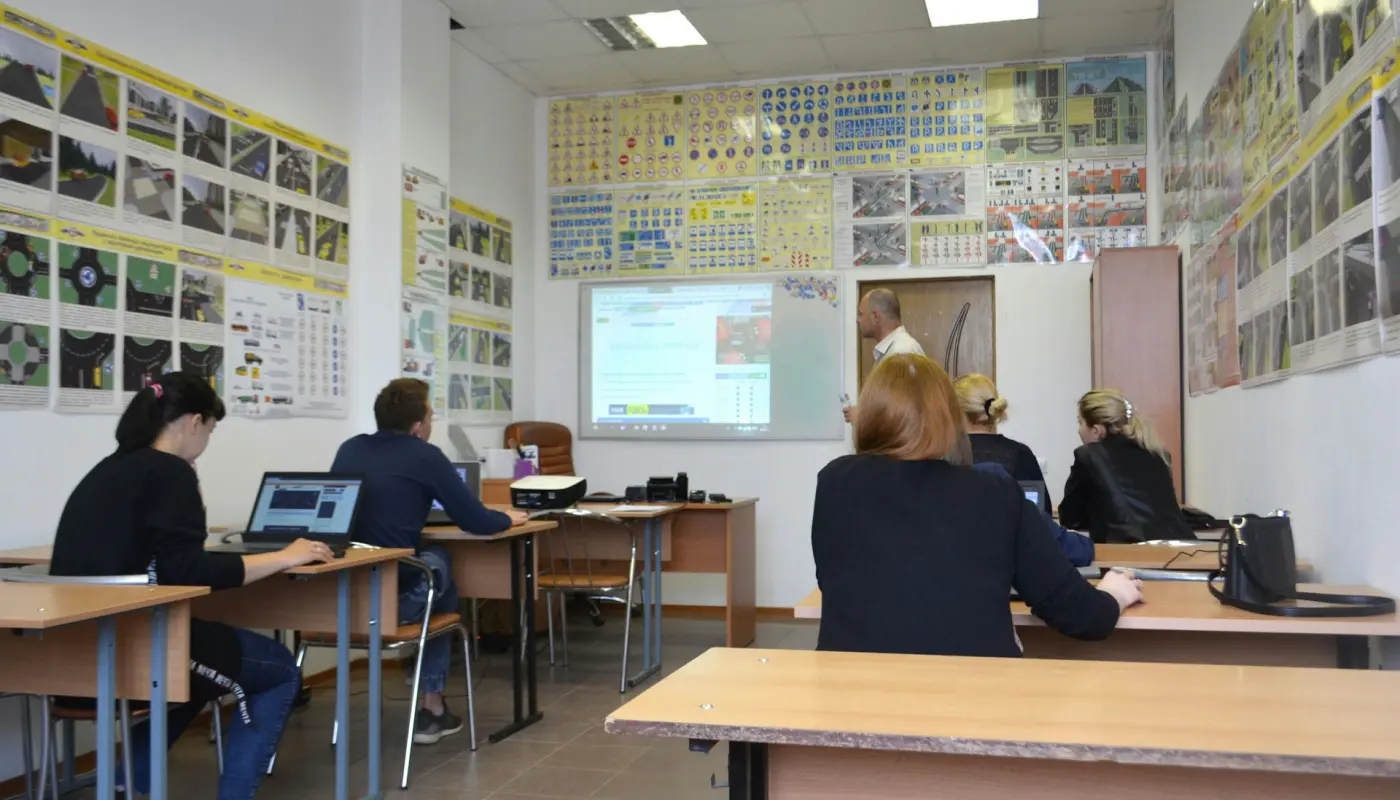 salle de formation avec participants écoutant un présentateur devant un écran de projection