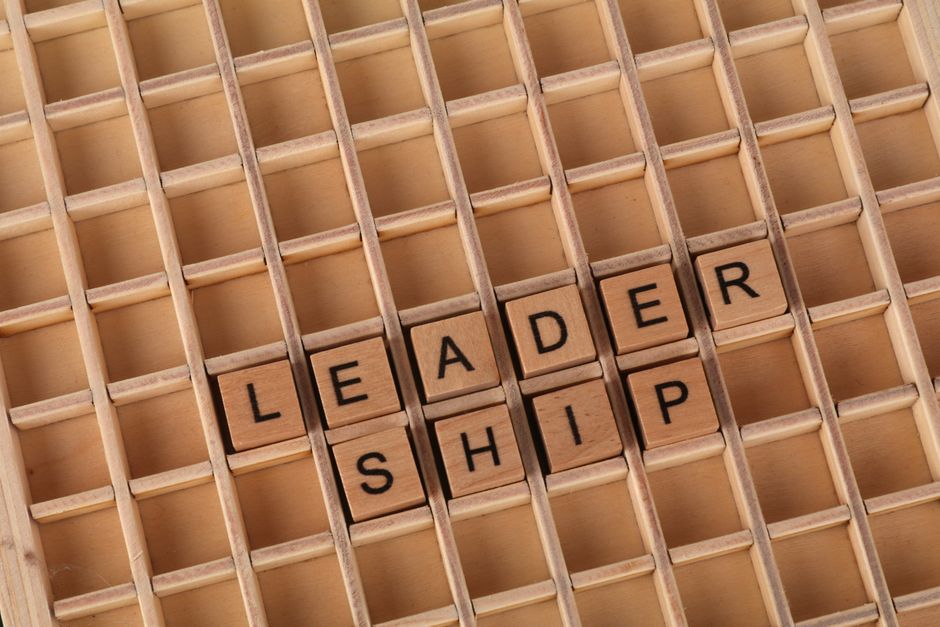 Wooden letter blocks spelling 'LEADERSHIP' on a grid background, emphasizing the leadership concept.