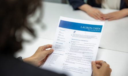 a woman is reading a resume at a table